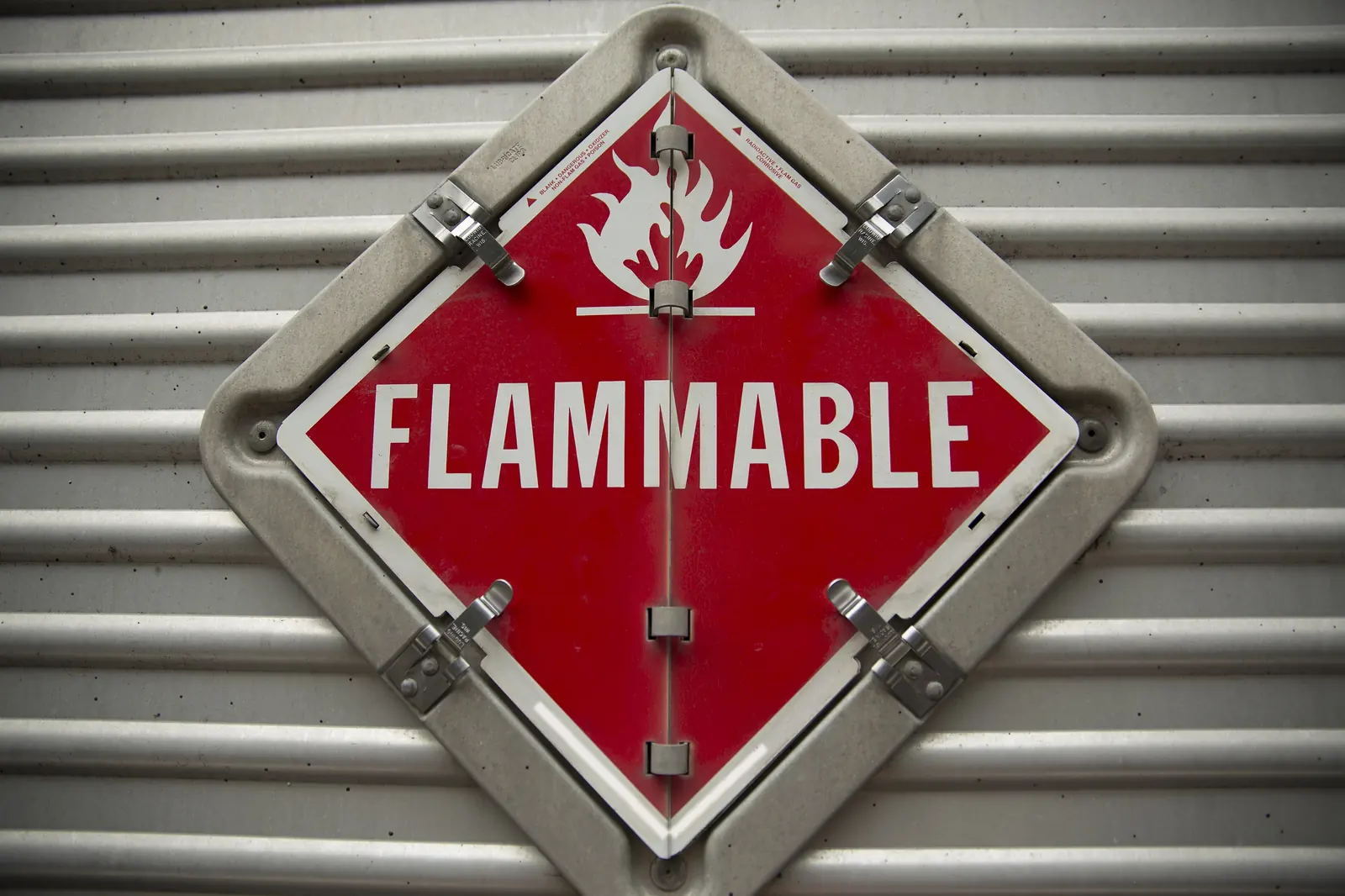 A red Flammable hazmat placard mounted on the side of a truck trailer